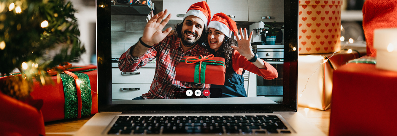 Two people celebrating the holidays shown on a computer screen