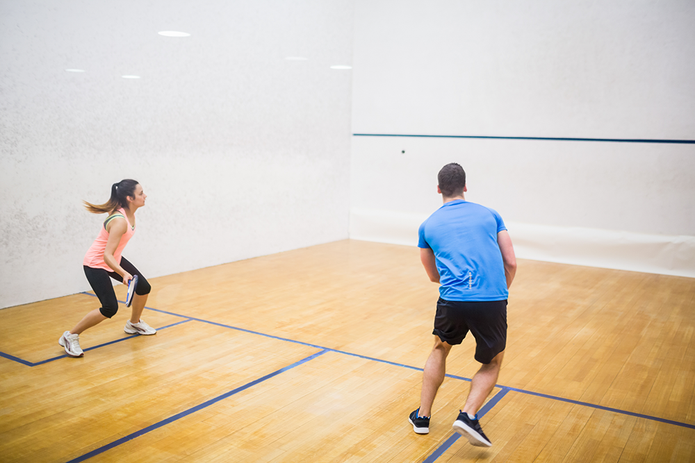 A couple is playing squash indoor